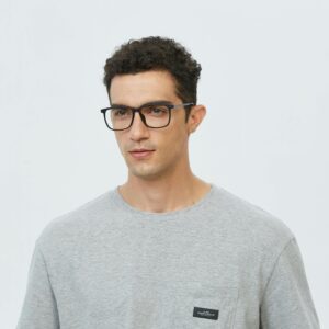 Portrait of a young man wearing glasses in a casual gray t-shirt, looking pensive.